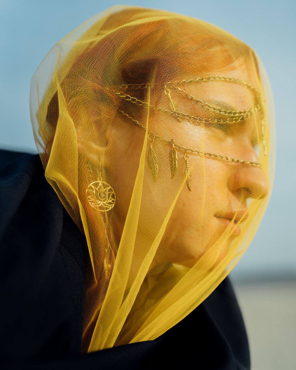 Close-up portrait of woman wearing delicate silver facechain with geometric design